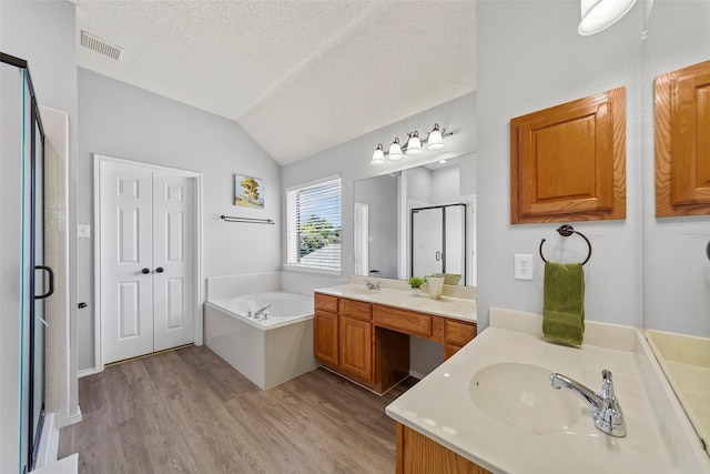 1106 Brook Ridge Ave, Allen, TX 75002 - bathroom featuring wood finished floors, a shower stall, two vanities, a bath, and vaulted ceiling