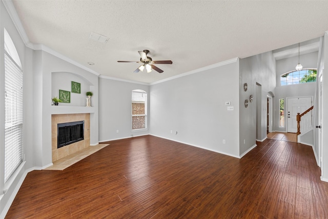 1106 Brook Ridge Ave, Allen, TX 75002 - unfurnished living room featuring a tile fireplace, ceiling fan, dark wood-type flooring, a textured ceiling, and stairway