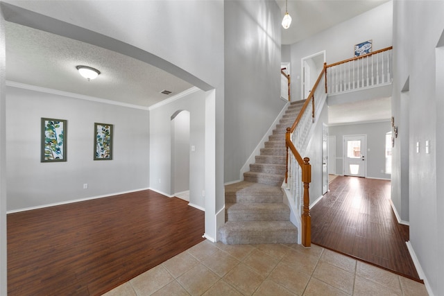 1106 Brook Ridge Ave, Allen, TX 75002 - tiled entryway with arched walkways, baseboards, ornamental molding, stairs, and a textured ceiling
