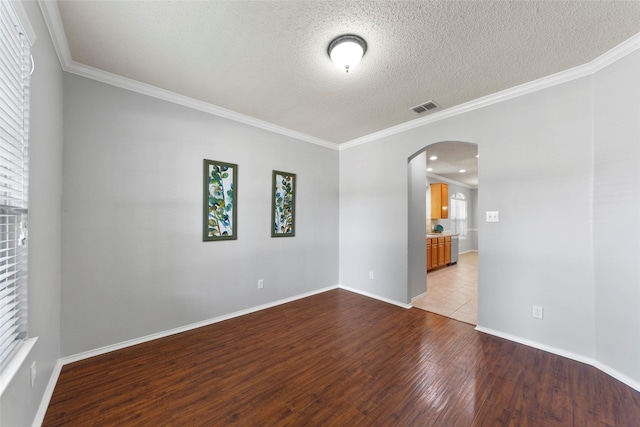 1106 Brook Ridge Ave, Allen, TX 75002 - empty room with arched walkways, wood finished floors, crown molding, a textured ceiling, and baseboards