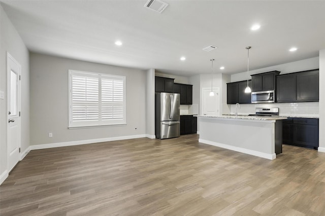 1253 Presidio Ln, Weatherford, TX 76087 - kitchen featuring appliances with stainless steel finishes, a sink, recessed lighting, light wood-style flooring, and tasteful backsplash