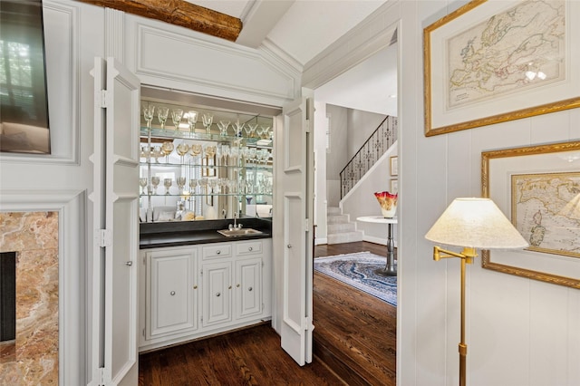6015 Meadowcreek Dr, Dallas, TX 75248 - indoor wet bar with stairs, a decorative wall, dark wood finished floors, and ornamental molding