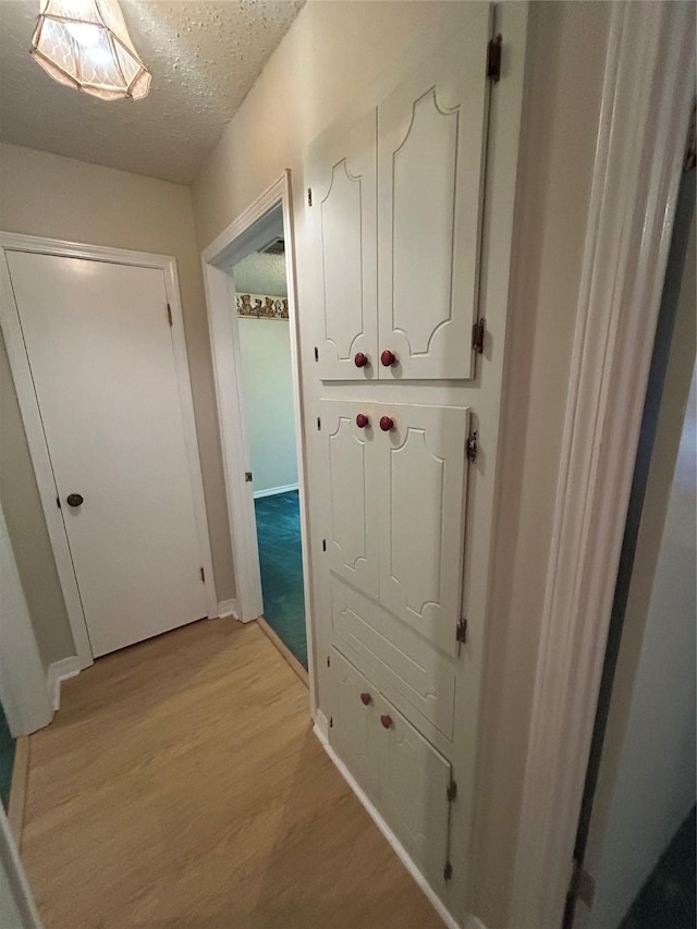 7834 Womack Rd, Shreveport, LA 71107 - hall with light wood finished floors, a textured ceiling, and baseboards