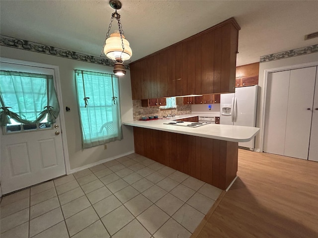 7834 Womack Rd, Shreveport, LA 71107 - kitchen featuring white appliances, light countertops, a peninsula, backsplash, and decorative light fixtures