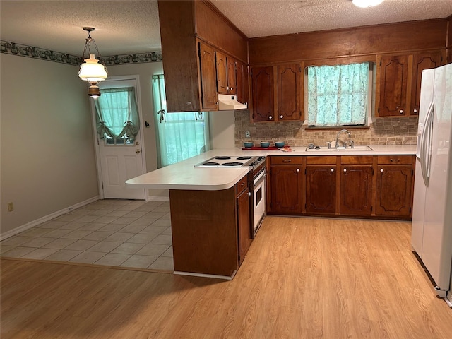7834 Womack Rd, Shreveport, LA 71107 - kitchen featuring under cabinet range hood, a sink, white appliances, light countertops, and a textured ceiling