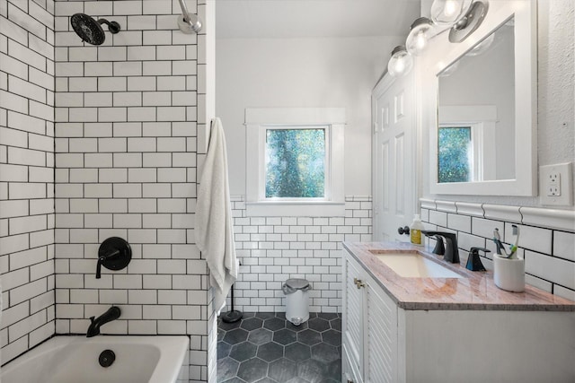 308 W Heard St, Cleburne, TX 76033 - bathroom with tile walls, plenty of natural light, tile patterned floors, vanity, and shower / tub combination