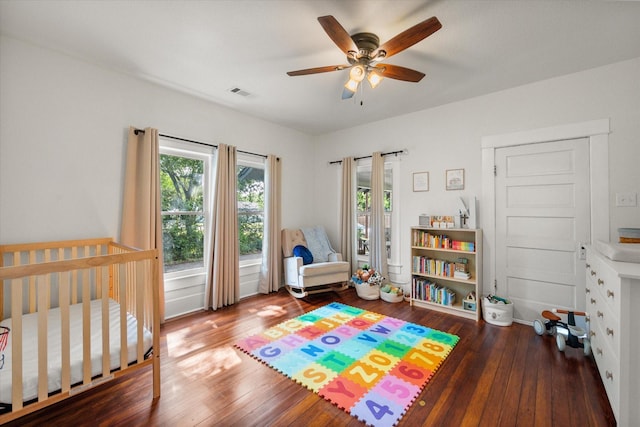 308 W Heard St, Cleburne, TX 76033 - bedroom with wood-type flooring, a ceiling fan, and a nursery area
