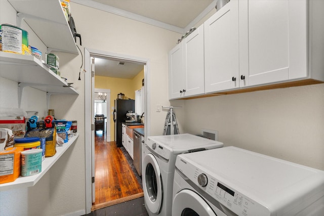 308 W Heard St, Cleburne, TX 76033 - washroom featuring washer and dryer, cabinet space, and dark wood-style flooring