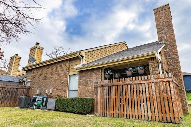 2101 Park Willow Ln Unit A, Arlington, TX 76011 - back of house featuring brick siding, cooling unit, a chimney, and roof with shingles