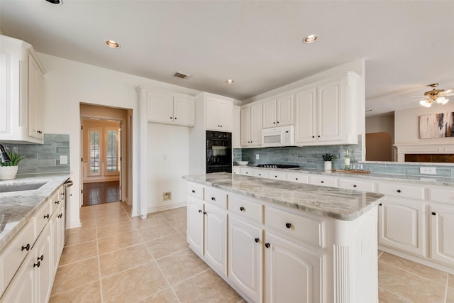 402 Thistle Ct, Southlake, TX 76092 - kitchen with white microwave, gas cooktop, tasteful backsplash, light tile patterned flooring, and white cabinets
