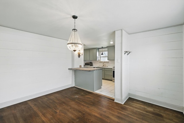 932 N Woods St, Sherman, TX 75092 - kitchen featuring gray cabinets, wood finished floors, a chandelier, and a peninsula