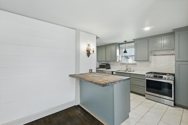 932 N Woods St, Sherman, TX 75092 - kitchen with stainless steel gas stove, a sink, tasteful backsplash, a peninsula, and a kitchen breakfast bar