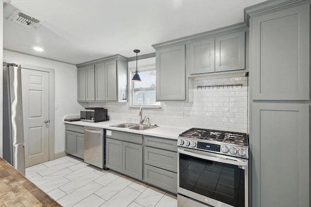 932 N Woods St, Sherman, TX 75092 - kitchen with gray cabinets, appliances with stainless steel finishes, a sink, and decorative backsplash