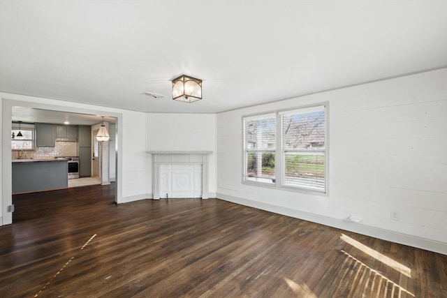 932 N Woods St, Sherman, TX 75092 - unfurnished living room featuring dark wood-style flooring and baseboards