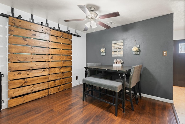7504 Kingsmill Ter, Fort Worth, TX 76112 - dining area featuring a barn door, wood finished floors, ceiling fan, and baseboards