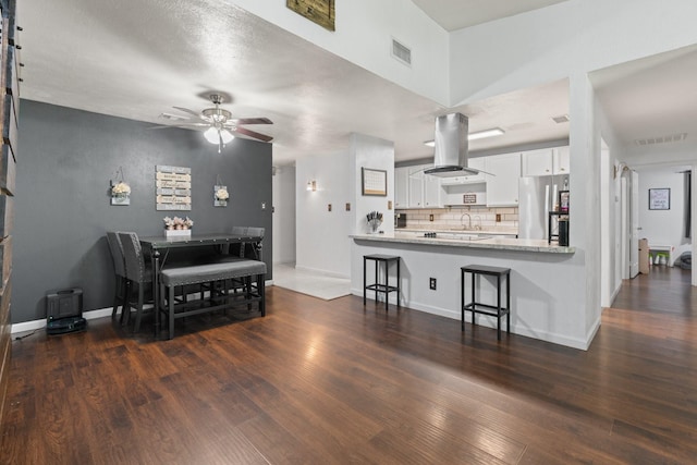 7504 Kingsmill Ter, Fort Worth, TX 76112 - kitchen with freestanding refrigerator, island exhaust hood, decorative backsplash, and dark wood-style flooring