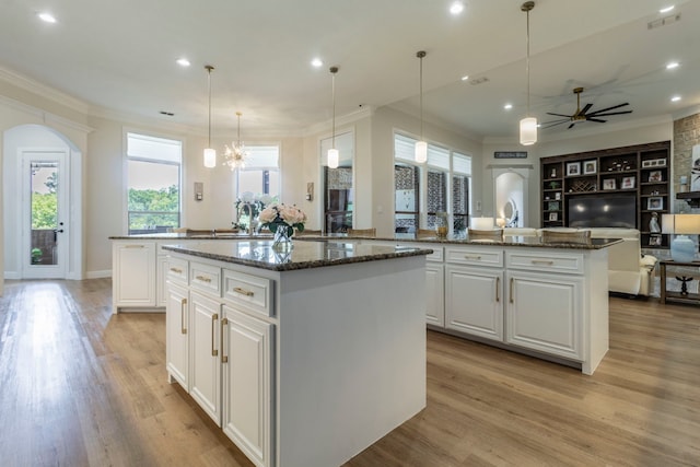 3340 Pleasantville Rd, Midlothian, TX 76065 - kitchen featuring a center island with sink, arched walkways, ornamental molding, light wood-style flooring, and a ceiling fan