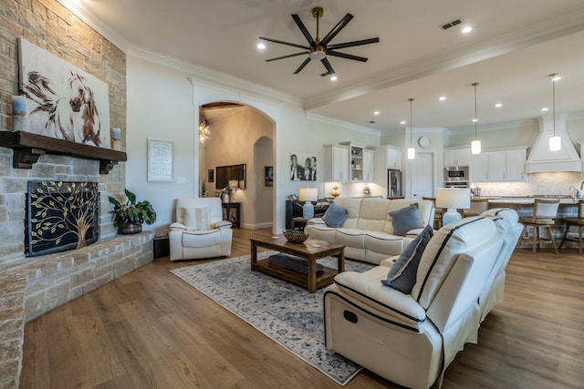 3340 Pleasantville Rd, Midlothian, TX 76065 - living area with ceiling fan, arched walkways, crown molding, wood finished floors, and a fireplace