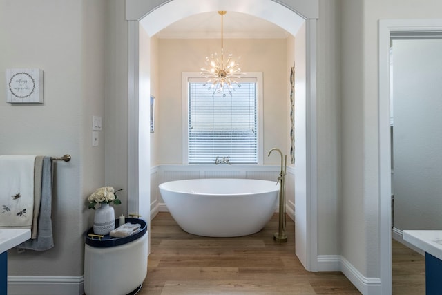3340 Pleasantville Rd, Midlothian, TX 76065 - bathroom featuring a chandelier, a freestanding tub, wood finished floors, a wainscoted wall, and vanity