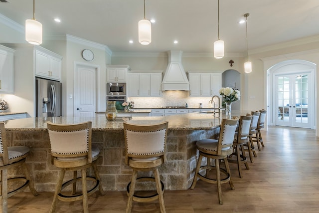 3340 Pleasantville Rd, Midlothian, TX 76065 - kitchen featuring appliances with stainless steel finishes, custom exhaust hood, a spacious island, french doors, and backsplash