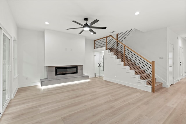 4523 Wahoo St, Dallas, TX 75210 - unfurnished living room with stairway, a glass covered fireplace, ceiling fan, light wood finished floors, and recessed lighting