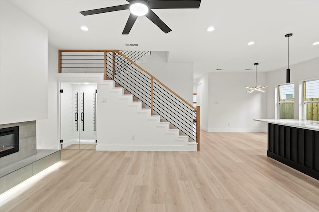 4523 Wahoo St, Dallas, TX 75210 - unfurnished living room featuring ceiling fan, a tiled fireplace, baseboards, light wood-type flooring, and recessed lighting