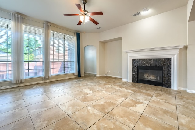 2128 Chambers Dr, Allen, TX 75013 - unfurnished living room with tile patterned flooring, arched walkways, ceiling fan, a fireplace, and baseboards