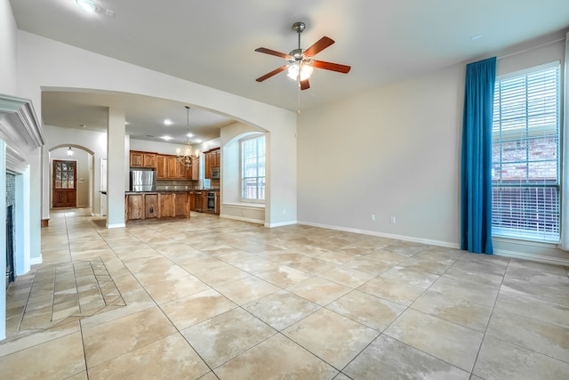 2128 Chambers Dr, Allen, TX 75013 - unfurnished living room featuring light tile patterned floors, arched walkways, and a ceiling fan