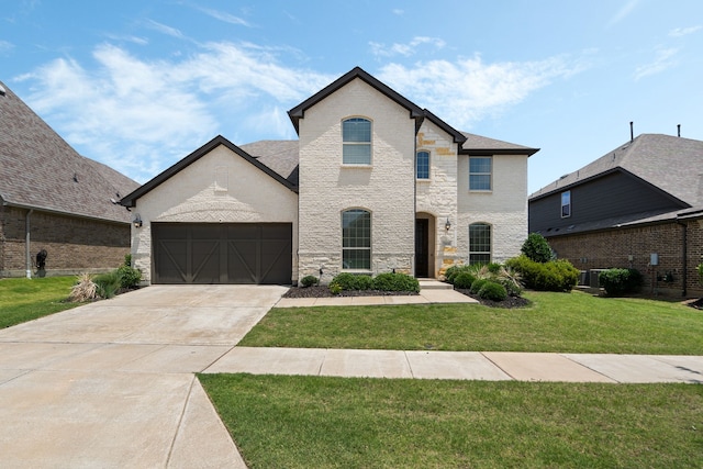 7020 Cross Point Ln, Little Elm, TX 76227 - french country home with a front yard, concrete driveway, stone siding, brick siding, and a garage