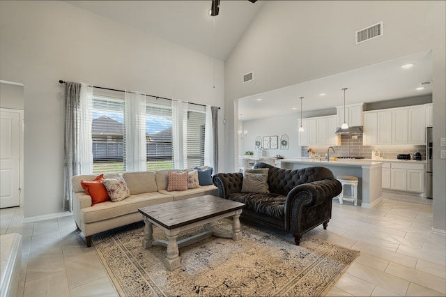 7020 Cross Point Ln, Little Elm, TX 76227 - living room featuring high vaulted ceiling, light tile patterned floors, and baseboards