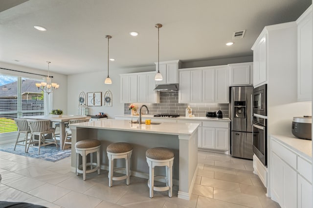 7020 Cross Point Ln, Little Elm, TX 76227 - kitchen featuring appliances with stainless steel finishes, a sink, light countertops, backsplash, and a breakfast bar area