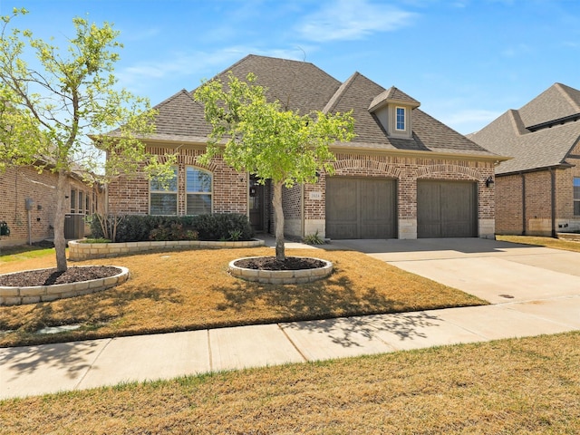 2624 Bellevue, The Colony, TX 75056 - french country home with brick siding, a garage, driveway, a shingled roof, and cooling unit
