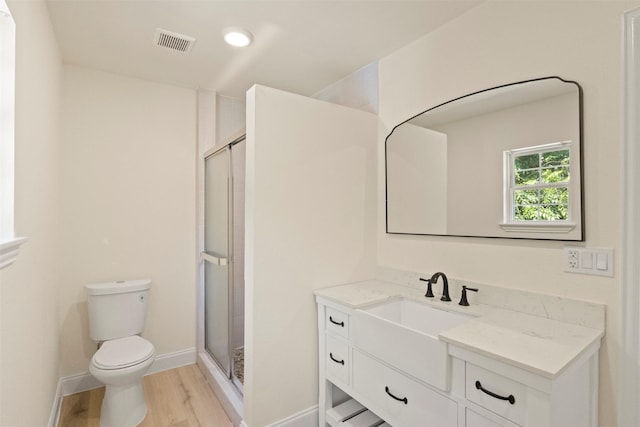 2810 Altman Dr, Irving, TX 75062 - full bathroom with toilet, wood finished floors, vanity, a shower stall, and baseboards