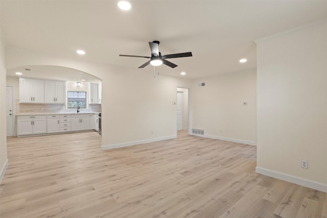 2810 Altman Dr, Irving, TX 75062 - unfurnished living room with ceiling fan, baseboards, recessed lighting, light wood finished floors, and arched walkways