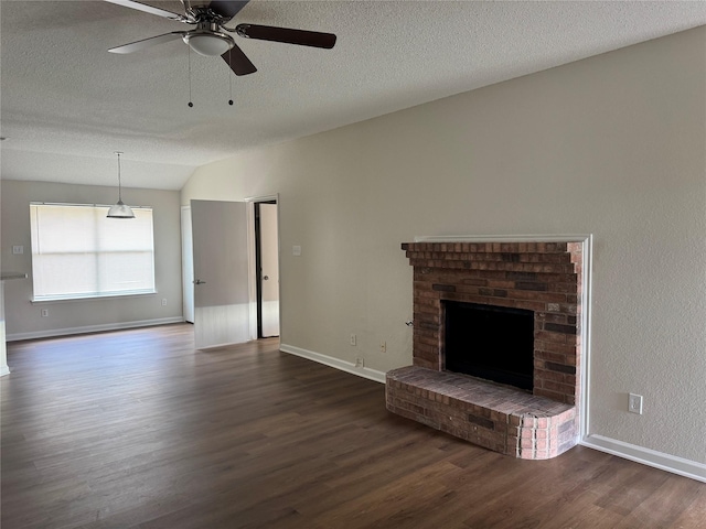 195 Rolling Ct, Lancaster, TX 75146 - unfurnished living room with a brick fireplace, dark wood-style flooring, a ceiling fan, a textured ceiling, and baseboards