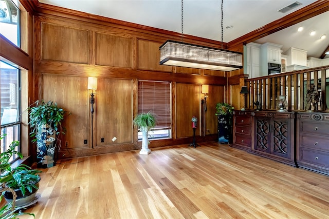2310 Castle Rock Rd, Arlington, TX 76006 - unfurnished living room featuring light wood-style flooring, wooden walls, and ornamental molding