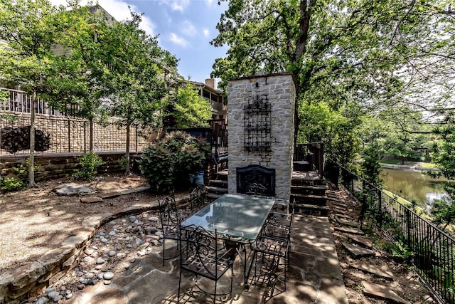 2310 Castle Rock Rd, Arlington, TX 76006 - view of patio featuring outdoor dining space, a water view, and an outdoor stone fireplace