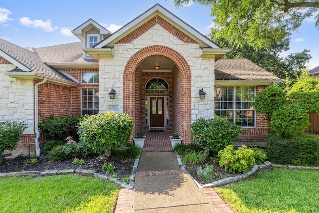4206 Creekbluff Dr, Rowlett, TX 75088 - property entrance with stone siding, a shingled roof, and brick siding