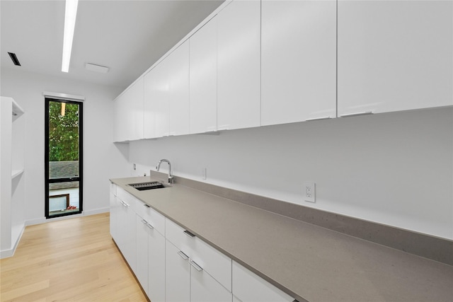 5029 Pershing St, Dallas, TX 75206 - kitchen with a sink, white cabinetry, light wood finished floors, baseboards, and modern cabinets