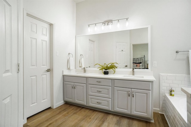 211 Windsong Way, Allen, TX 75002 - bathroom featuring double vanity, wood finished floors, and a bath