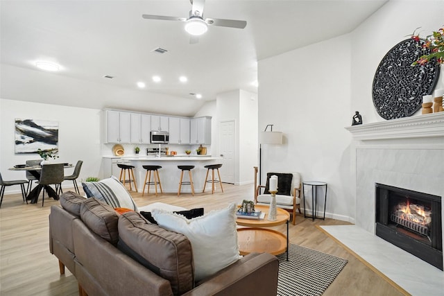 211 Windsong Way, Allen, TX 75002 - living room featuring ceiling fan, light wood-style floors, a fireplace, baseboards, and lofted ceiling