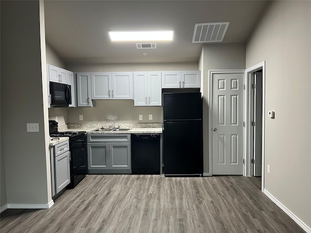 6108 Abrams Rd Unit 215, Dallas, TX 75231 - kitchen featuring black appliances, a sink, wood finished floors, light countertops, and baseboards