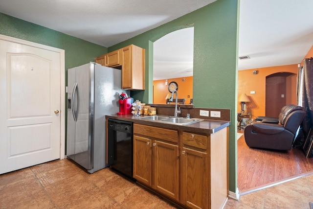 419 NW Murphy Rd, Burleson, TX 76028 - kitchen featuring black dishwasher, arched walkways, dark countertops, and stainless steel fridge