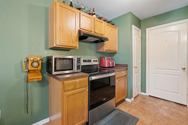 419 NW Murphy Rd, Burleson, TX 76028 - kitchen featuring under cabinet range hood, appliances with stainless steel finishes, dark countertops, and light brown cabinetry