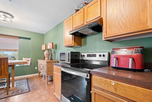 419 NW Murphy Rd, Burleson, TX 76028 - kitchen with appliances with stainless steel finishes, under cabinet range hood, dark countertops, and a textured ceiling