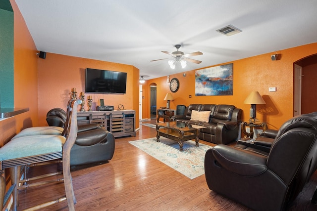 419 NW Murphy Rd, Burleson, TX 76028 - living room featuring arched walkways, ceiling fan, wood finished floors, and a textured wall