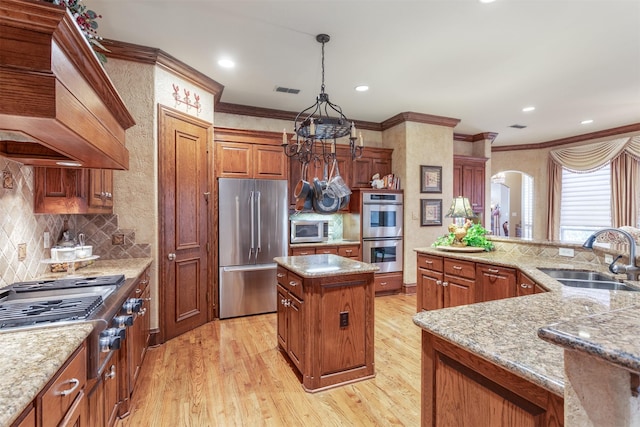 3401 Francesca Ct, Rowlett, TX 75088 - kitchen with appliances with stainless steel finishes, a sink, a kitchen island, light wood-type flooring, and ornamental molding