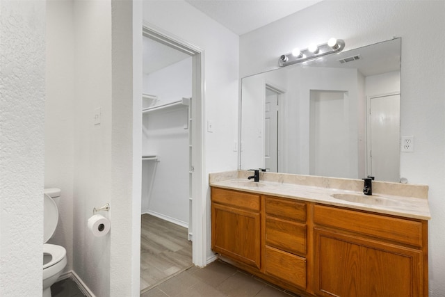8109 Dripping Springs Dr, Fort Worth, TX 76134 - bathroom featuring double vanity, toilet, and a walk in closet