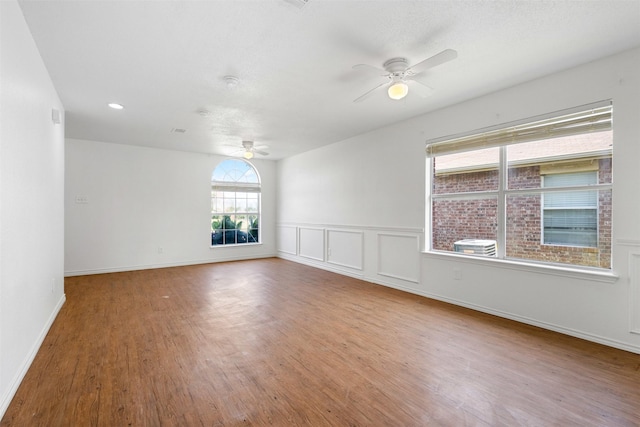 8109 Dripping Springs Dr, Fort Worth, TX 76134 - empty room featuring ceiling fan, wood finished floors, baseboards, and a wainscoted wall