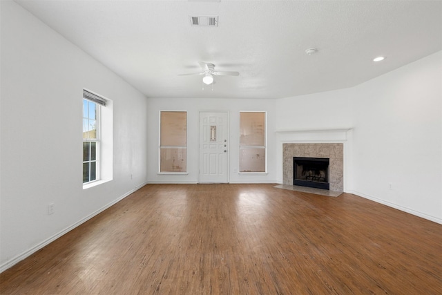 8109 Dripping Springs Dr, Fort Worth, TX 76134 - unfurnished living room with ceiling fan, wood finished floors, baseboards, and a tile fireplace